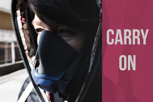 CARRY ON text, woman with a gas mask walking on the city streets surviving a corona virus pandemic or post atomic world