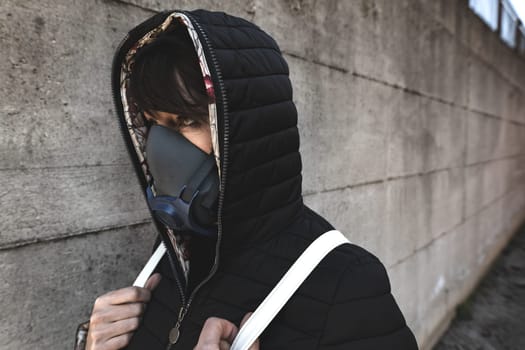 woman with a gas mask walking on the city streets surviving a corona virus pandemic or post atomic world