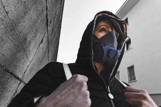 woman with a gas mask walking on the city streets surviving a corona virus pandemic or post atomic world