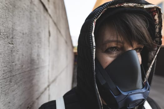 woman with a gas mask walking on the city streets surviving a corona virus pandemic or post atomic world