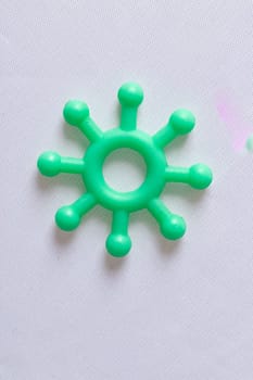 Single green plastic Covid-19 molecule model on a white background with copy space for use in coronavirus themed concepts