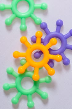 Colorful plastic models of the Covid-19 molecule in close up on white conceptual of the global coronavirus pandemic