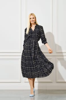 Smiling woman walking in wavy dress with pattern