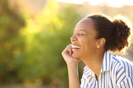 Funny black woman resting and laughing in a park