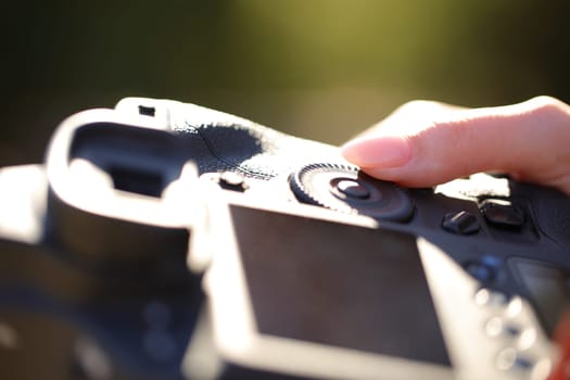Close up portrait of a photographer finger setting diaphragm aperture on camera dial