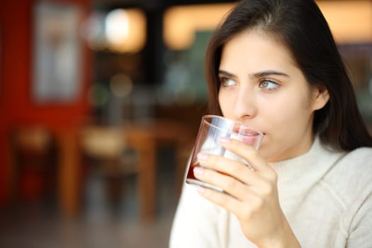 Restaurant customer drinking refreshment looking away