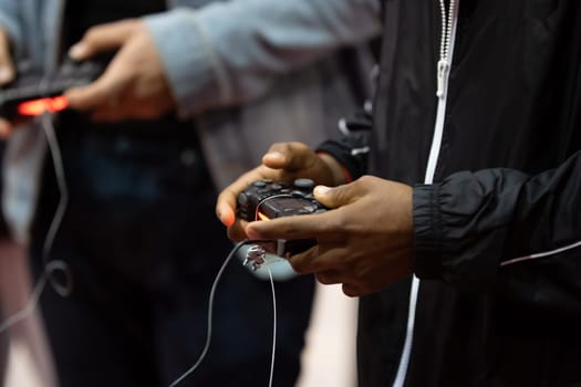 Men trying new console games using joysticks at game expo. Mid shot