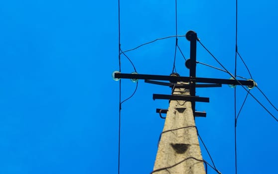 Electricity post in blue sky. Outdoor view. Electrical powered pillar. Power lines - Power Transmission Lines and blue sky. Electrical pole.