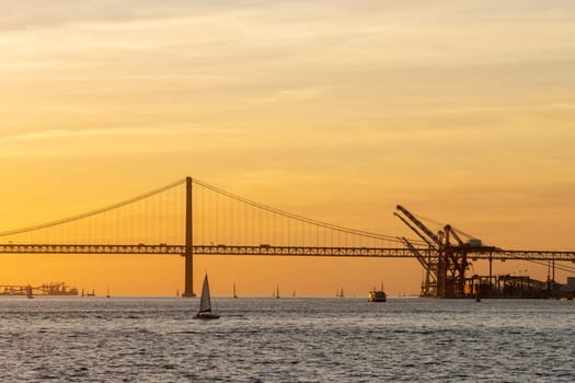 Bridge over the river and industrial cranes by the water. Mid shot