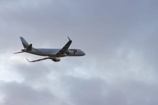 30 November 2022 PORTUGAL, LISBON: an AIRPORTUGAL passenger airplane flying in gray cloudy sky. Mid shot