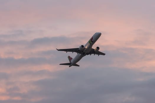 30 November 2022 PORTUGAL, LISBON: an airplane takes off at purple sunset. Mid shot