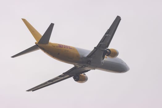 30 November 2022 PORTUGAL, LISBON: DHL aircraft fly up the sky. Mid shot