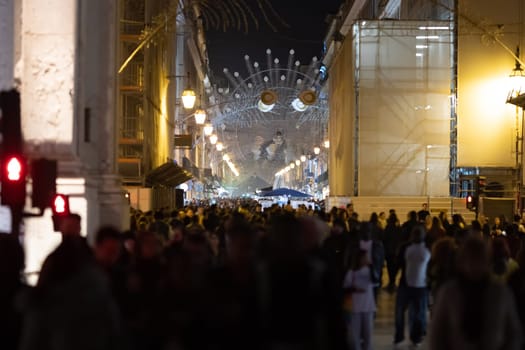 People walk along lisbon's main street decorated for christmas. Mid shot