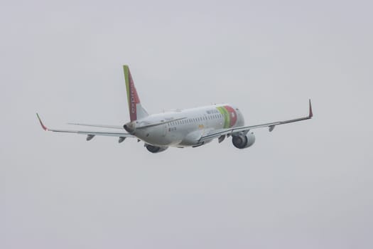 30 November 2022 PORTUGAL, LISBON: an AIRPORTUGAL airplane flying in grey sky. Mid shot
