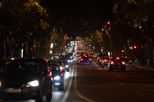 Cars stand in traffic jam on the road at night. Mid shot
