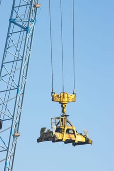 Industrial crane transfers the cargo from one place to another. Vertical shot