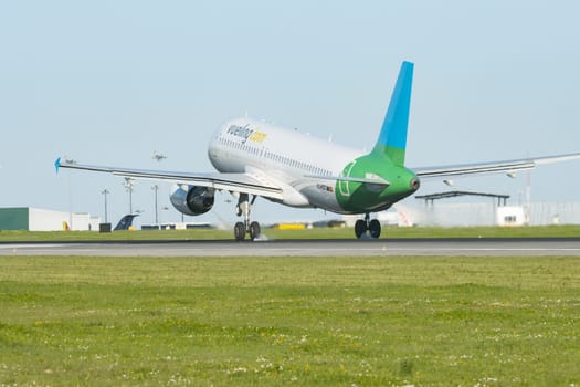 1 December 2022 PORTUGAL, LISBON: airplane with VUELING dot COM sign on the corpus taking off the runway. Mid shot