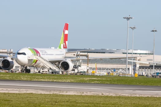 1 December 2022 PORTUGAL, LISBON: large passenger aircraft on the field by the airport. Mid shot