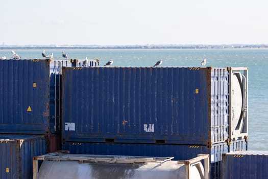 Blue cargo containers ready for loading in the seaport. Mid shot