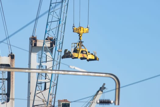 Industrial crane transfers cargo from one place to another. Mid shot