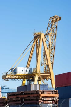 Yellow big crane operates in a warehouse at the seaport. Mid shot