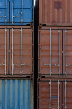 Closed doors of multicolored cargo containers in the port. Vertical shot