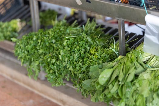 Fresh greens are sold on the market. Mid shot