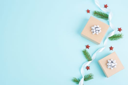 Christmas holiday greeting card with little gift boxes, stars and fir branches, blue background