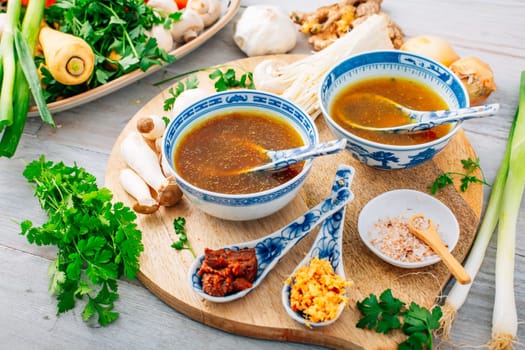 Miso, ramen or vegetable broth with ingredients on wooden background