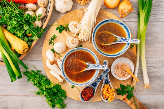 Miso, ramen or vegetable broth with ingredients on wooden background