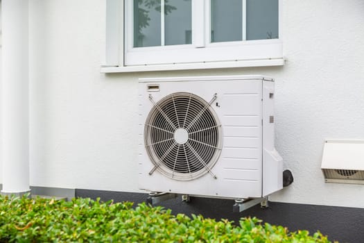Air source heat pumps installed outside of city house, green renewable energy concept of heat pump