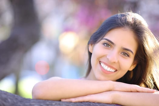 Front view portrait of a happy woman with white smile in a park