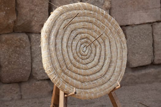 Ancient coiled straw target over wooden stand. Atreial material used by the archers of the Roman army