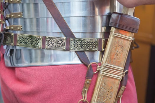 Roman legionnaire carrying his sword holstered in brass sheath, decorated with openwork incisions