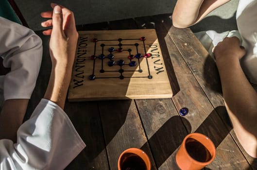 Reenactors playing molendinum, ancient roman board game