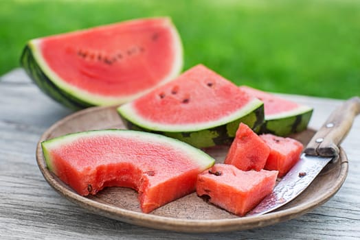 Fresh sliced watermelon in wooden table background outdoors