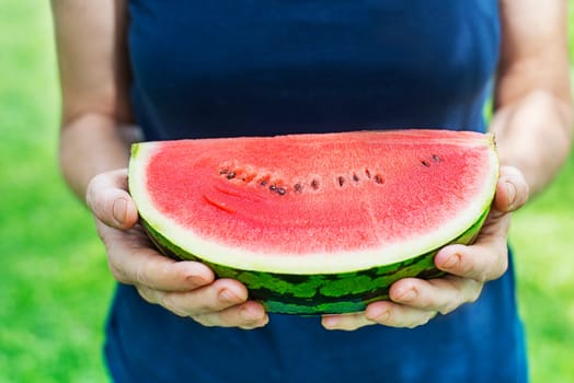 Woman holding fresh watermelon. Selective focus on the watermelon.