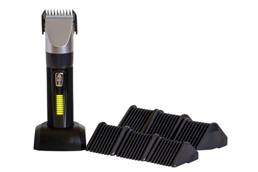 Close-up of a new black silver rechargeable beard and hair clipper with various attachment object isolated. Clipping path. Cordless hair and beard trimmer. Macro.