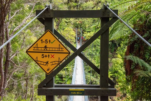 Warning signs about a suspension footbridge in Abel Tasman Cost Track, New Zealand