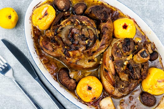 Roasted pork knuckle eisbein or knee cooked in dark beer and apples. Octoberfest party.