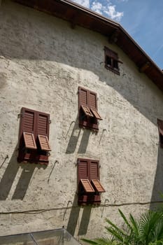 Shutters on the facade of an old residential building in the old town of Limone Sul Garda on Lake Garda in Italy