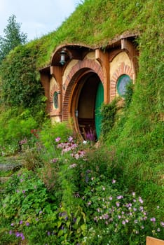 HOBBITON, NEW ZEALAND - JANUARY 20, 2023 - Bilbo Baggin's hobbit hole in Hobbiton village from the movies The Hobbit and Lord of the Rings, New Zealand