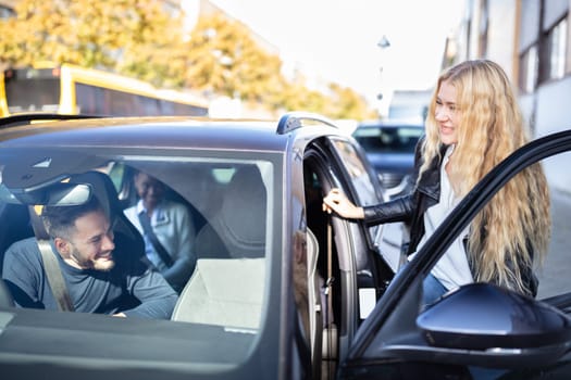 Happy Blonde Women Sitting Inside Car With Her Friends