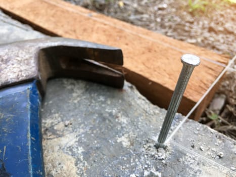 Concrete nails that are driven into the cement floor to tie ropes that will be used to find the width and length of the area for use in construction blurred background