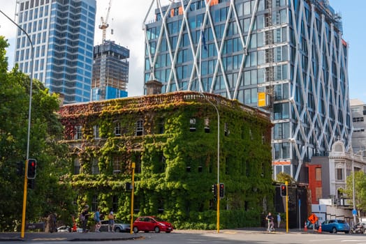 Old overgrown building between modern skyscrapers in Auckland, New Zealand