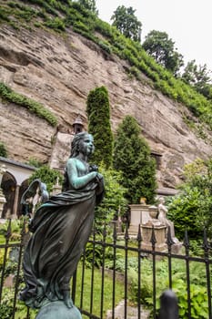 Beautiful sculpture of a girl at the grave of a cemetery in Salzburg, Austria