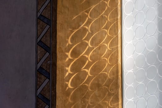 Sun shining through circled frosted glass and casting shadow on the wall