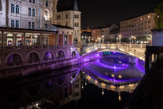 Famous three bridges at the Preseren square in the center of Ljubljana colorfully illuminated at night, Slovenia