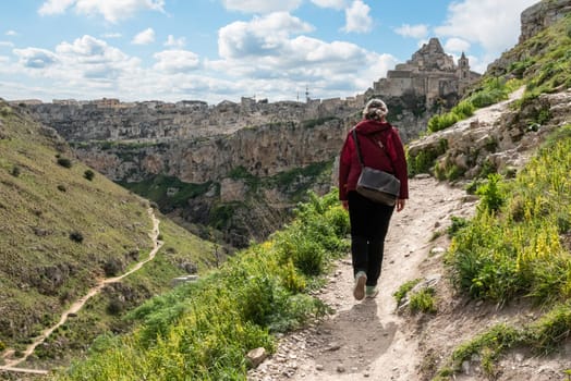 A woman hiking through the canyon of Matera, Southern Italy
