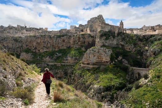 A woman hiking through the canyon of Matera, Southern Italy